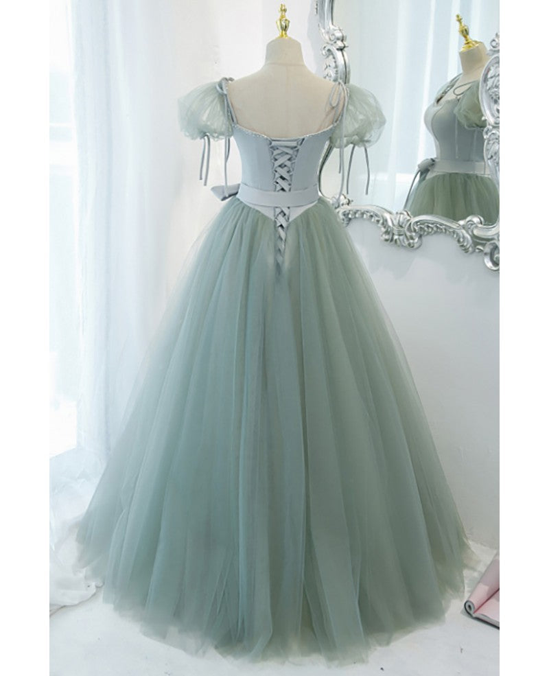Unico ed elegante abito da ballo verde menta con scollo quadrato, maniche corte e soffice, cintura con fiocco verde menta e spalline scoperte sulla schiena e abito da ballo lungo fino al pavimento.